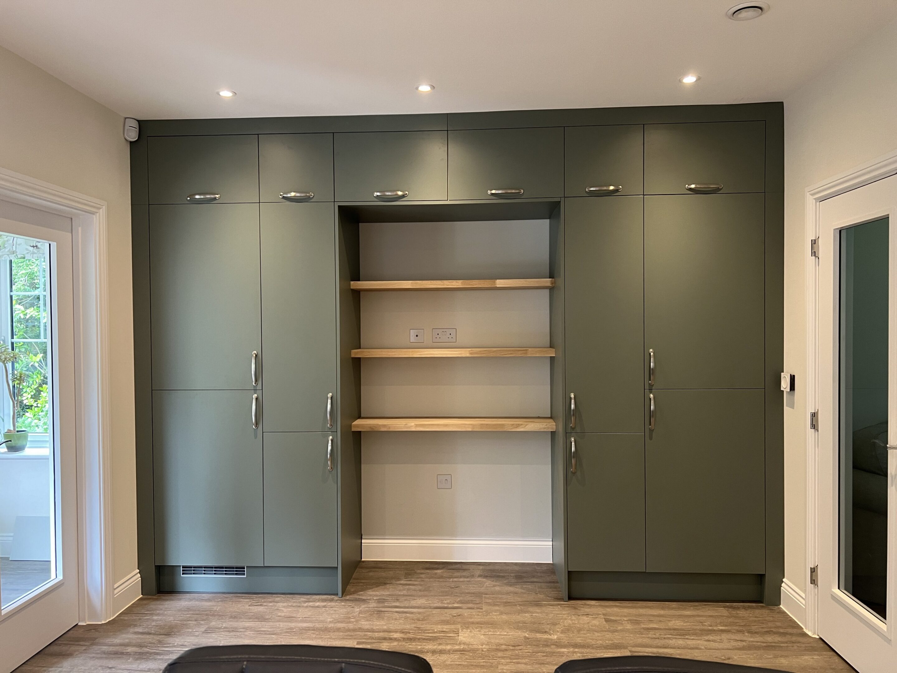 Green built-in wardrobes with central wooden shelves