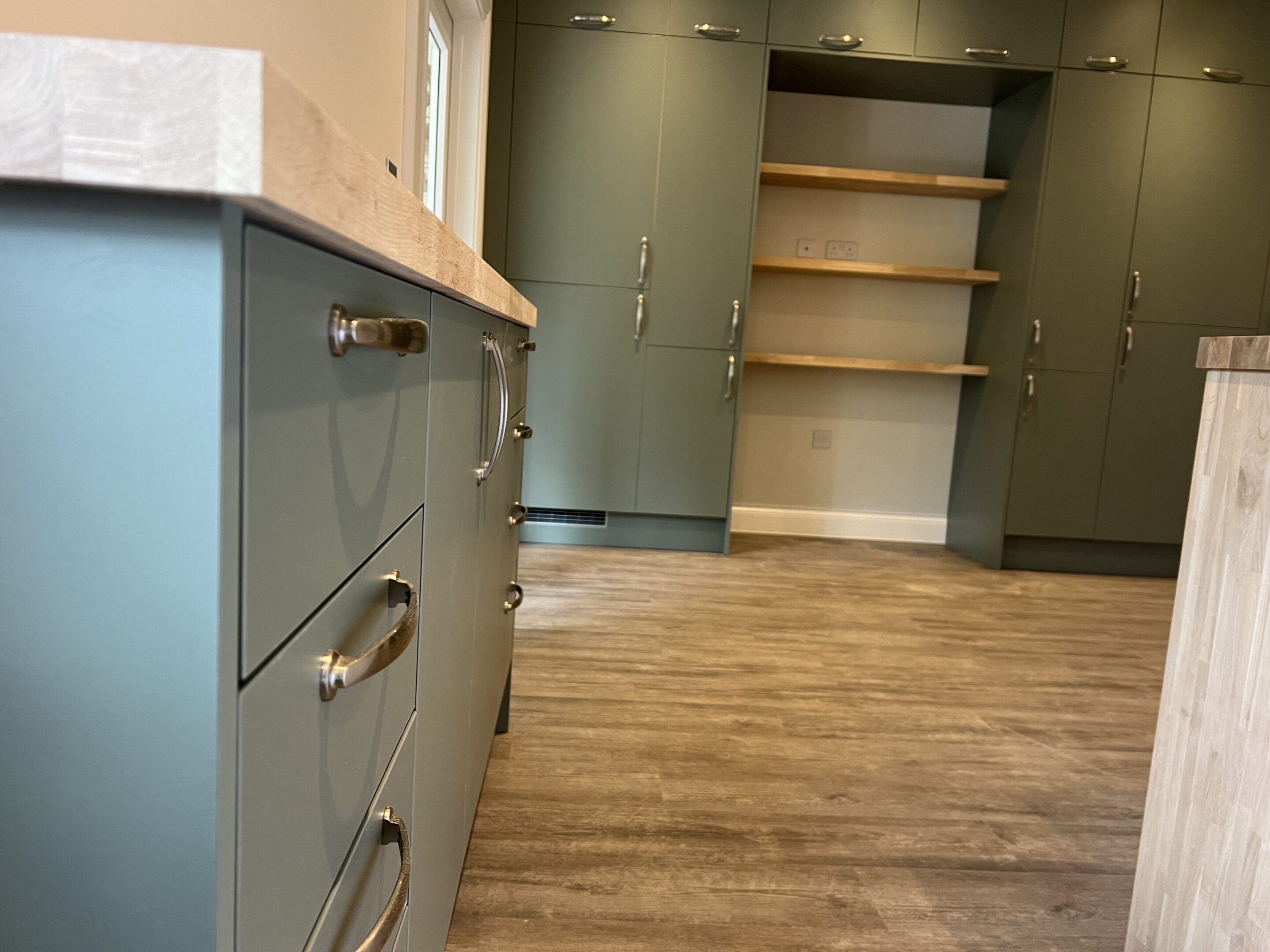 Sage green kitchen cabinets with open shelving