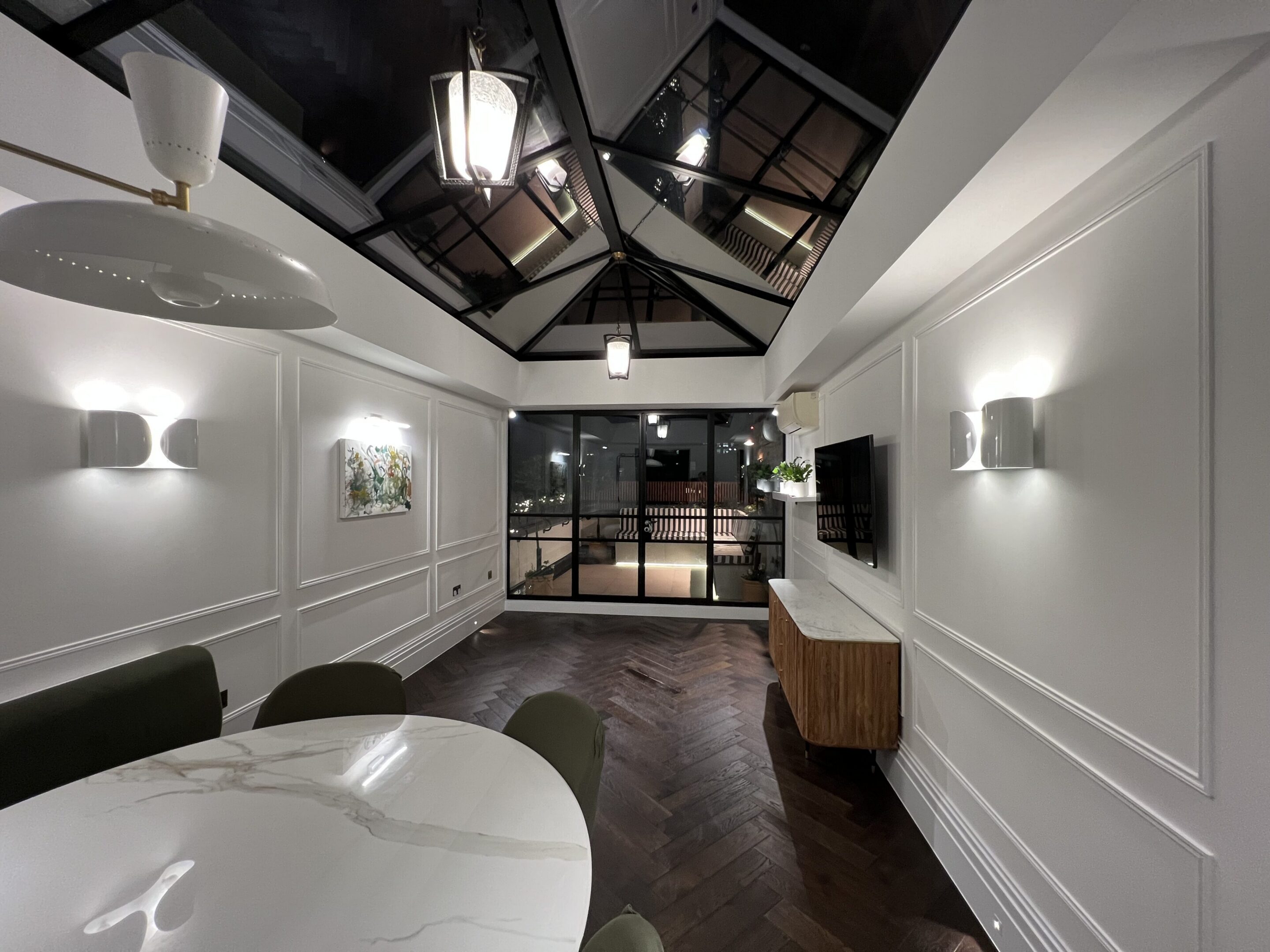Modern dining room with skylight and glass doors