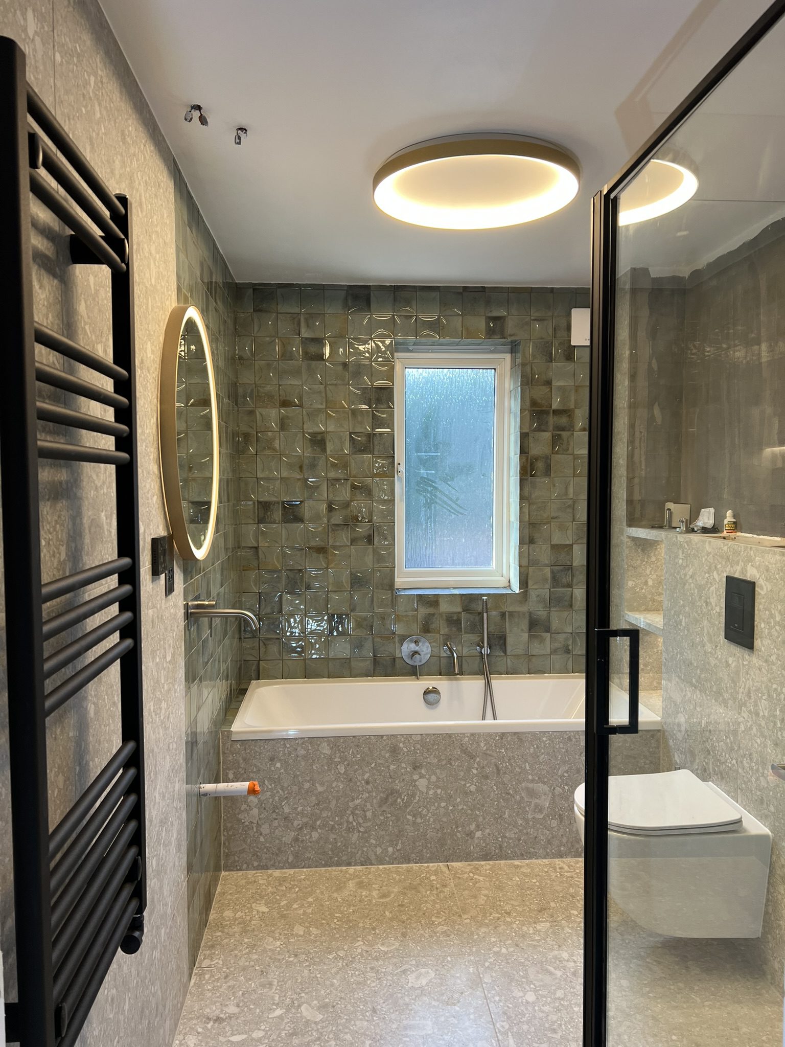 Modern bathroom with bathtub and illuminated mirror