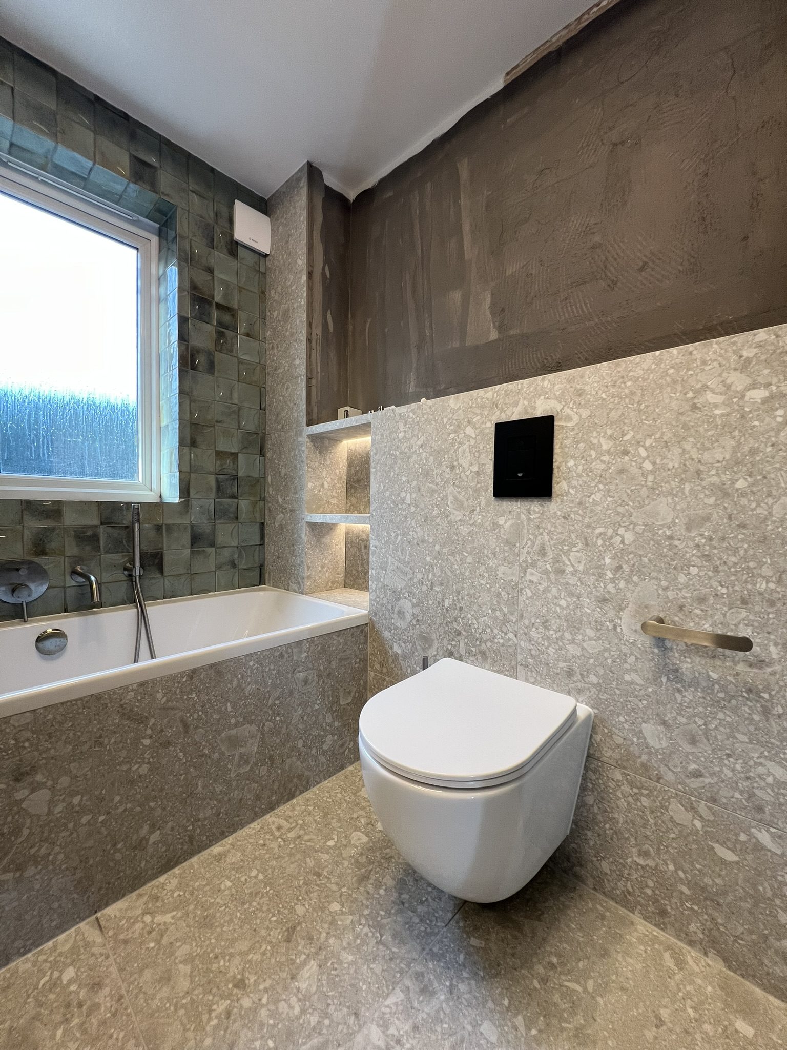 Modern bathroom with wall-mounted toilet and bathtub