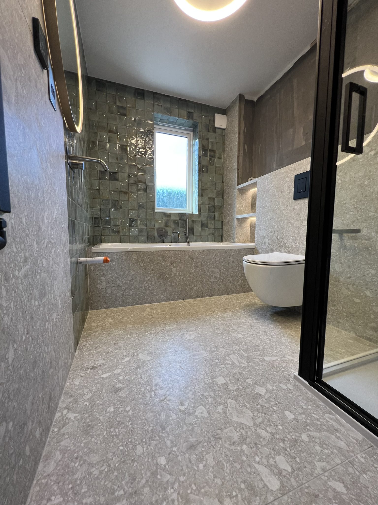 Modern gray bathroom with bathtub, shower, toilet