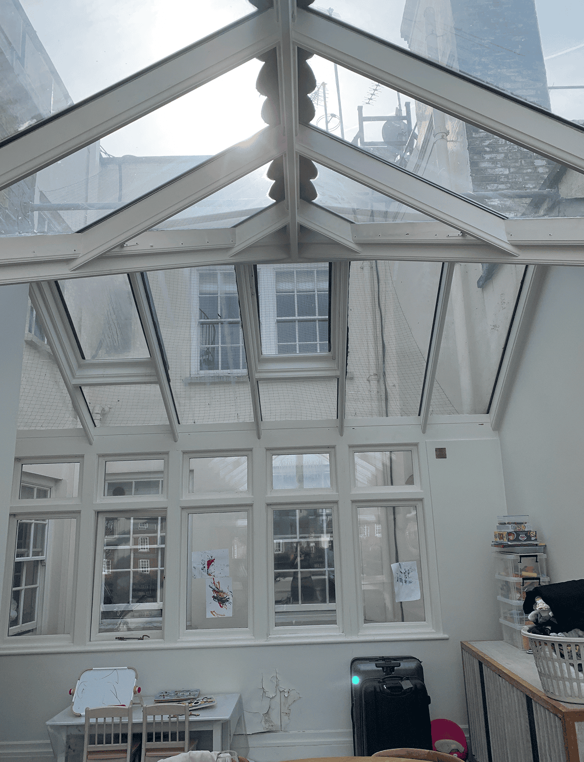 Bright glass-roofed conservatory room with windows