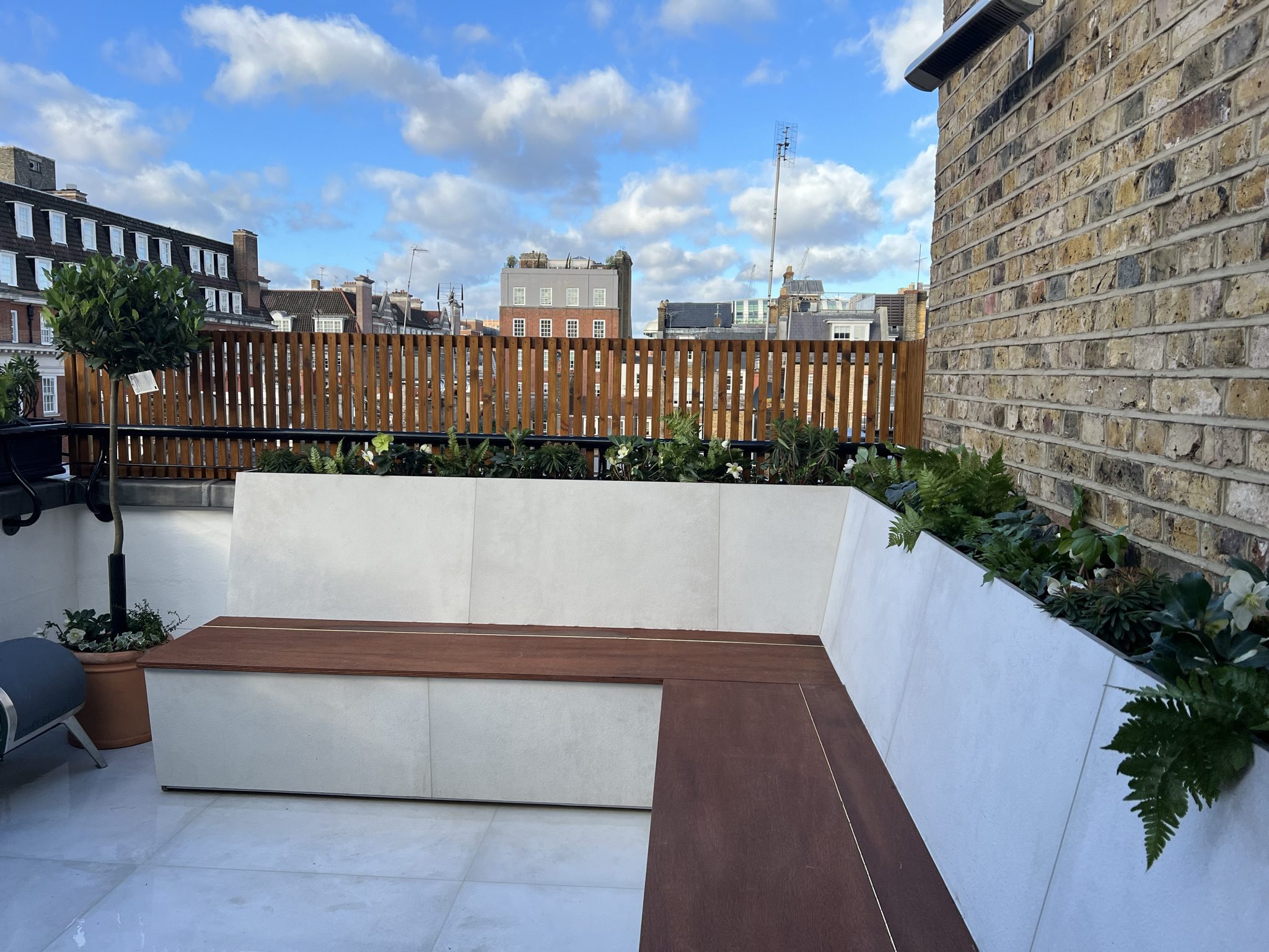Rooftop terrace with wooden bench and planters