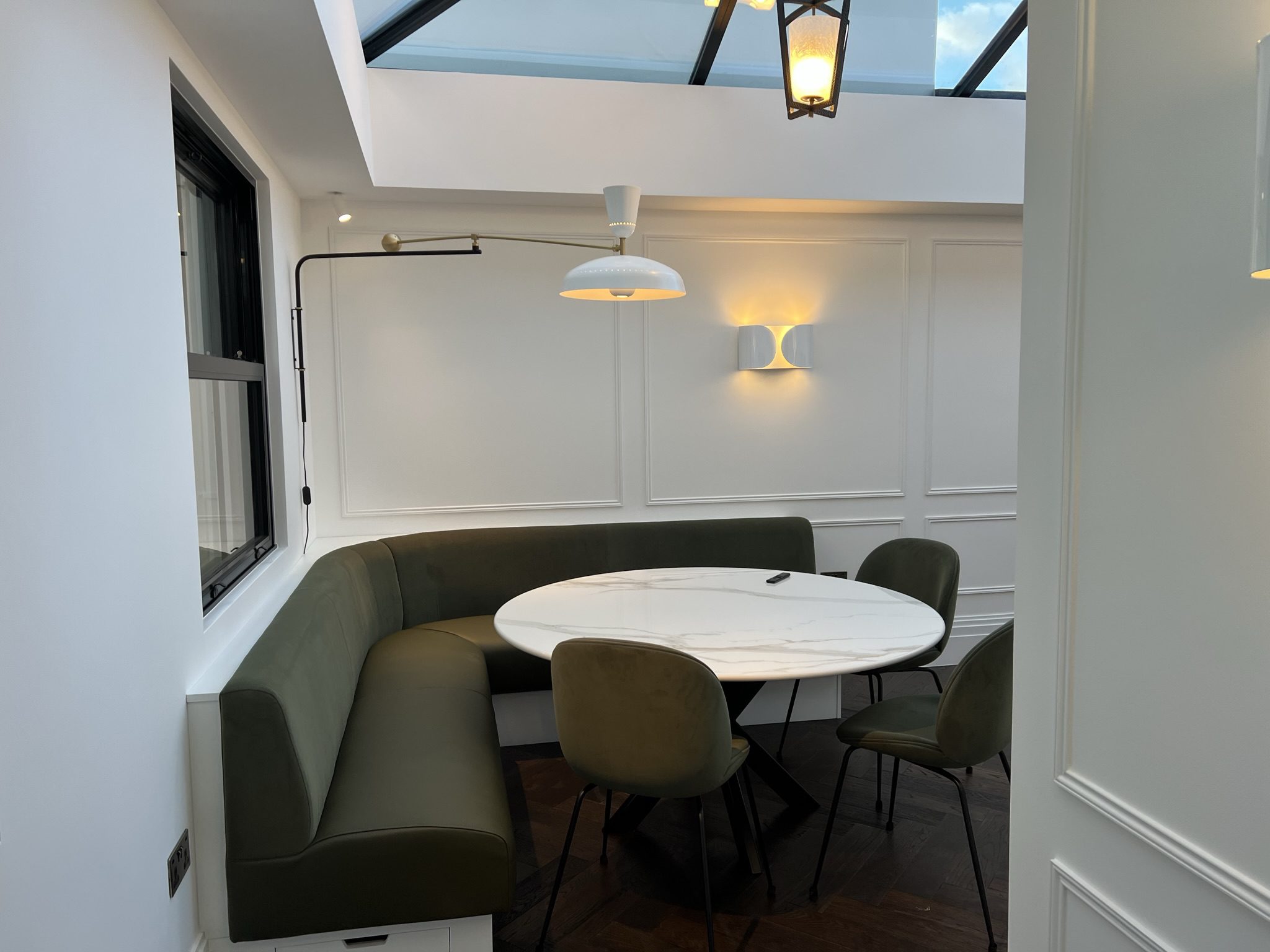 Modern dining nook with green banquette seating