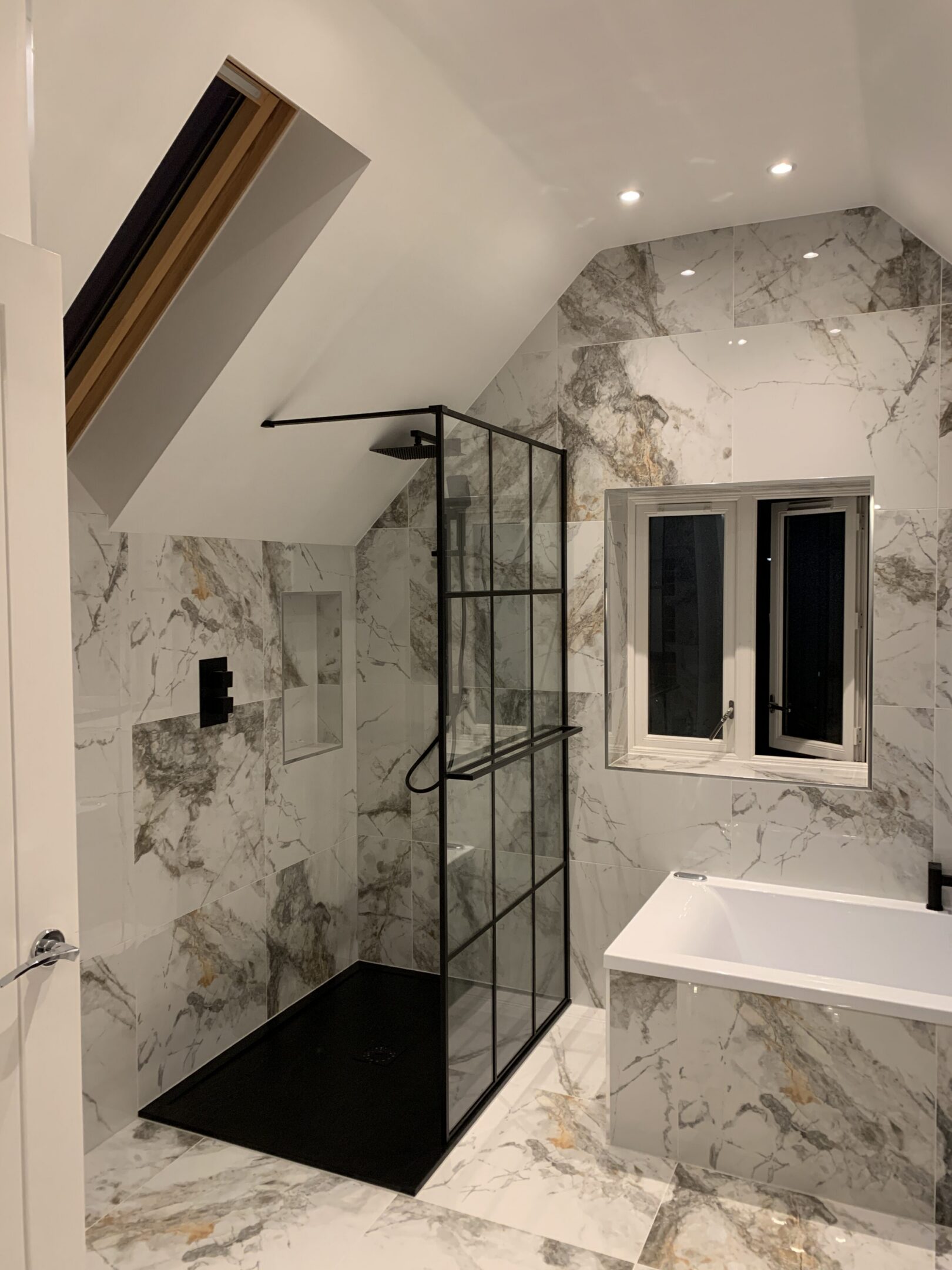 Modern marble bathroom with black-framed shower