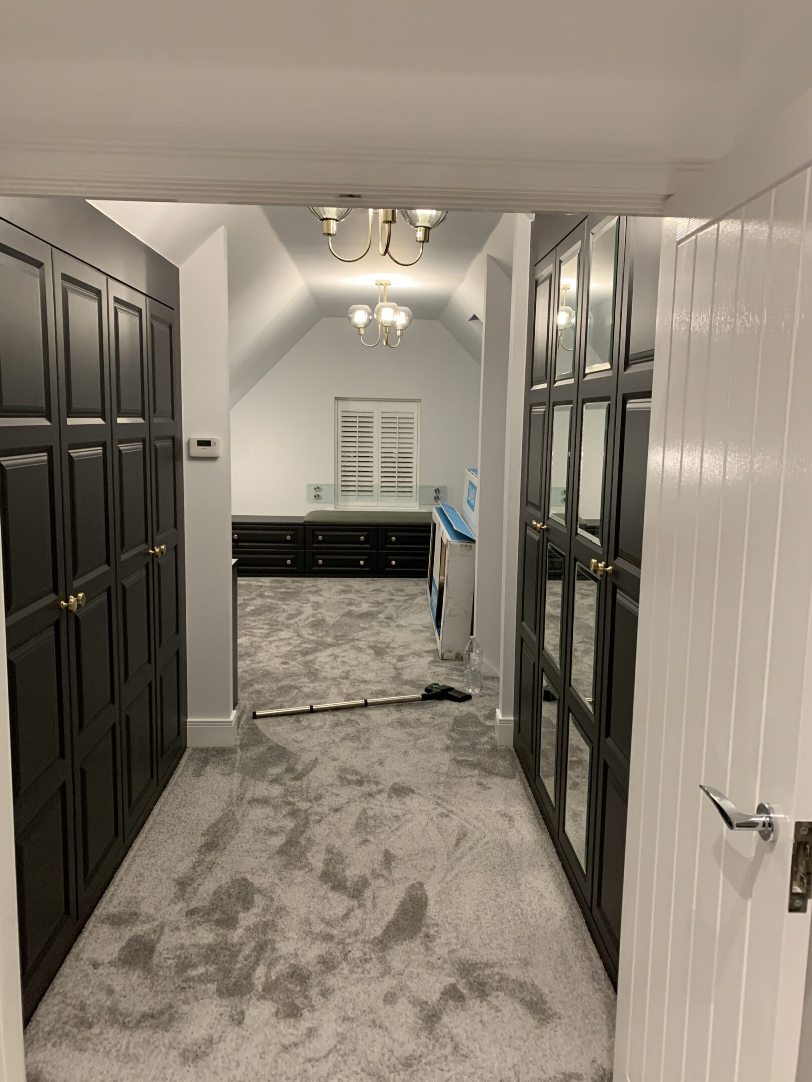 Carpeted hallway with black built-in cabinets