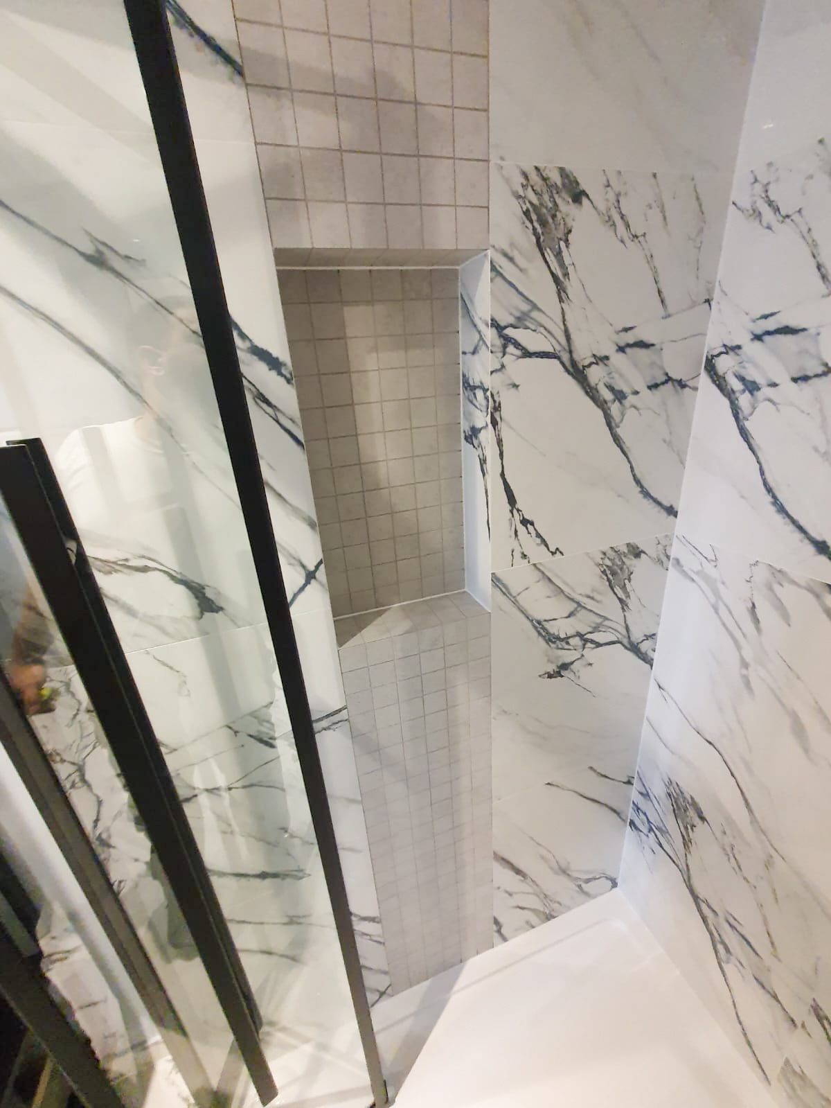 Marble-pattern shower with recessed tile niche