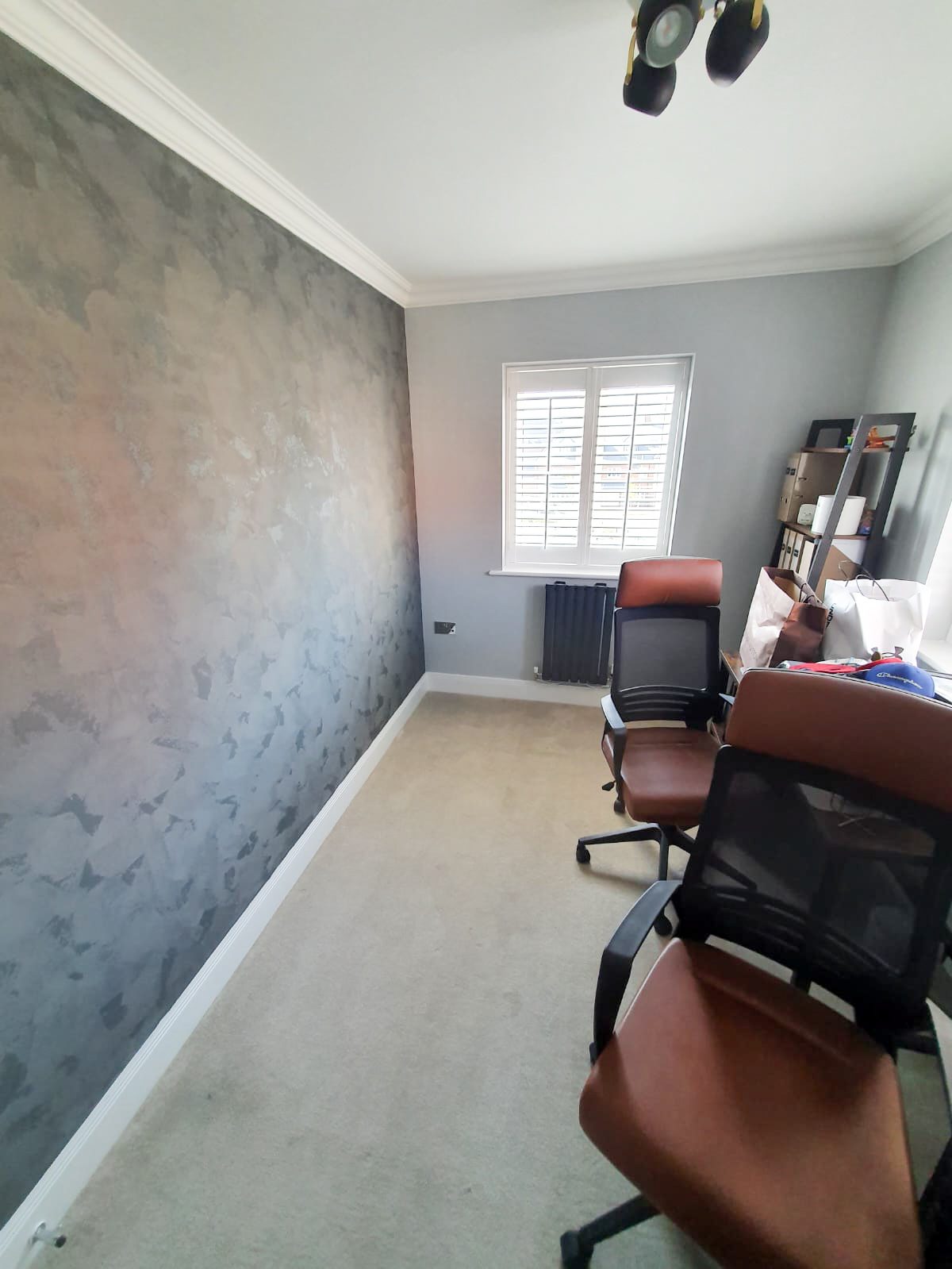 Small home office with textured gray wall, chairs