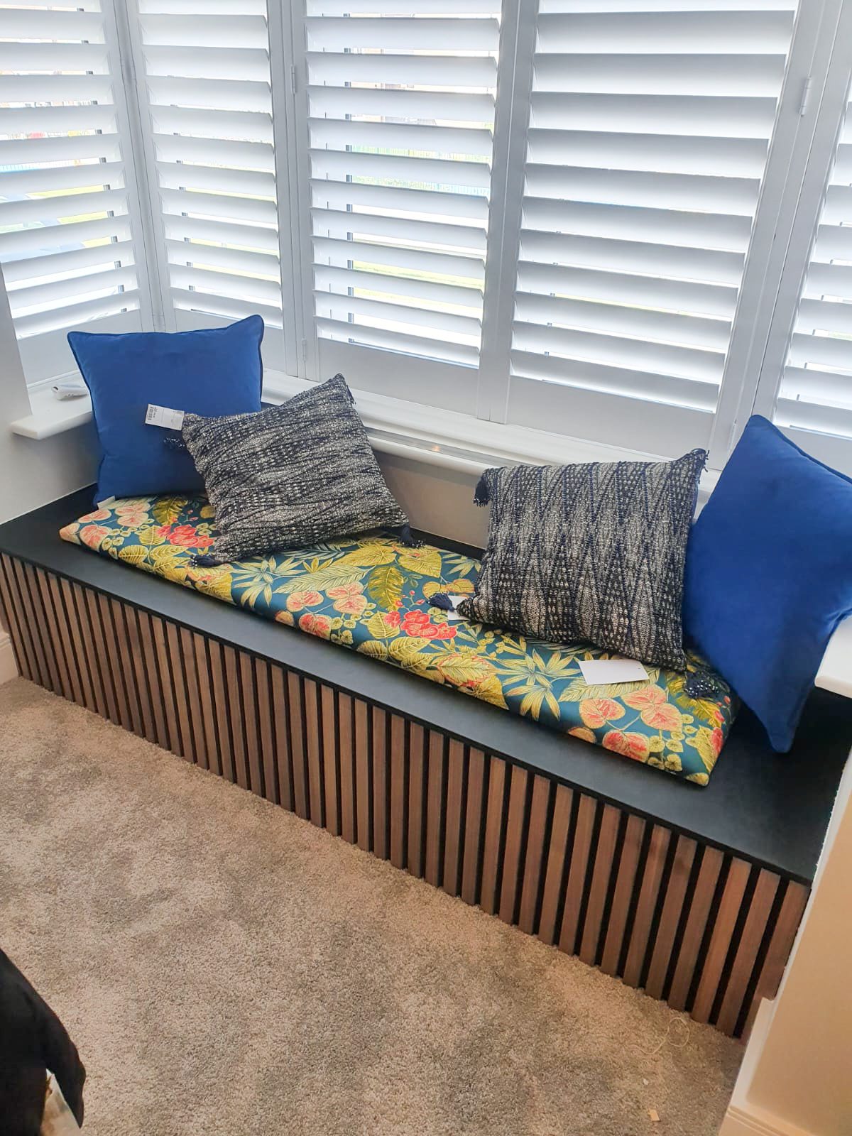 Window seat with floral cushion and blue pillows