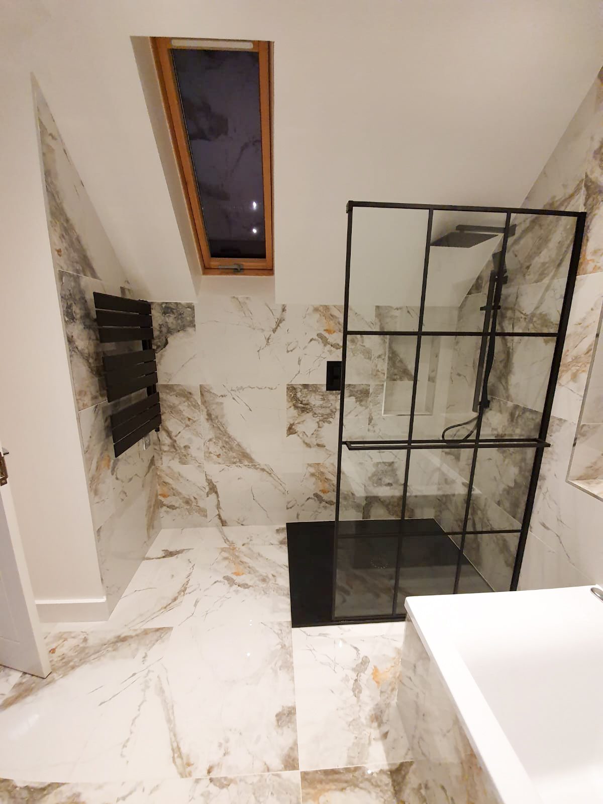 Modern marble bathroom with black-framed shower