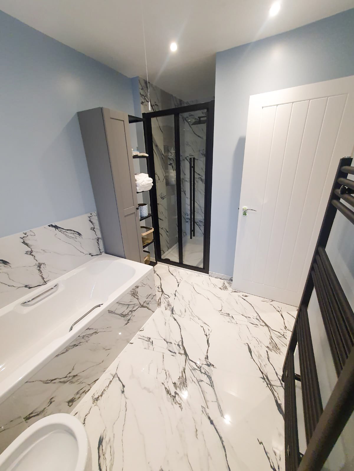 Modern bathroom with marble floor and black shower