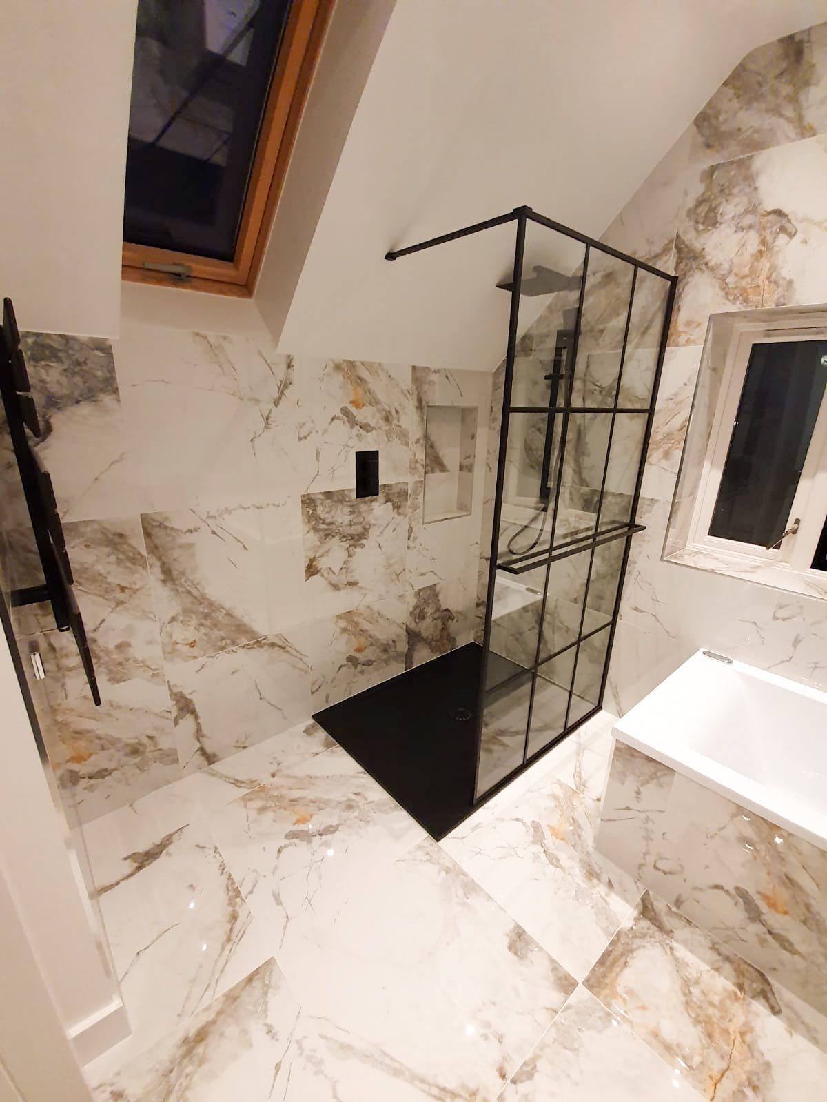 Modern marble bathroom with black-framed shower