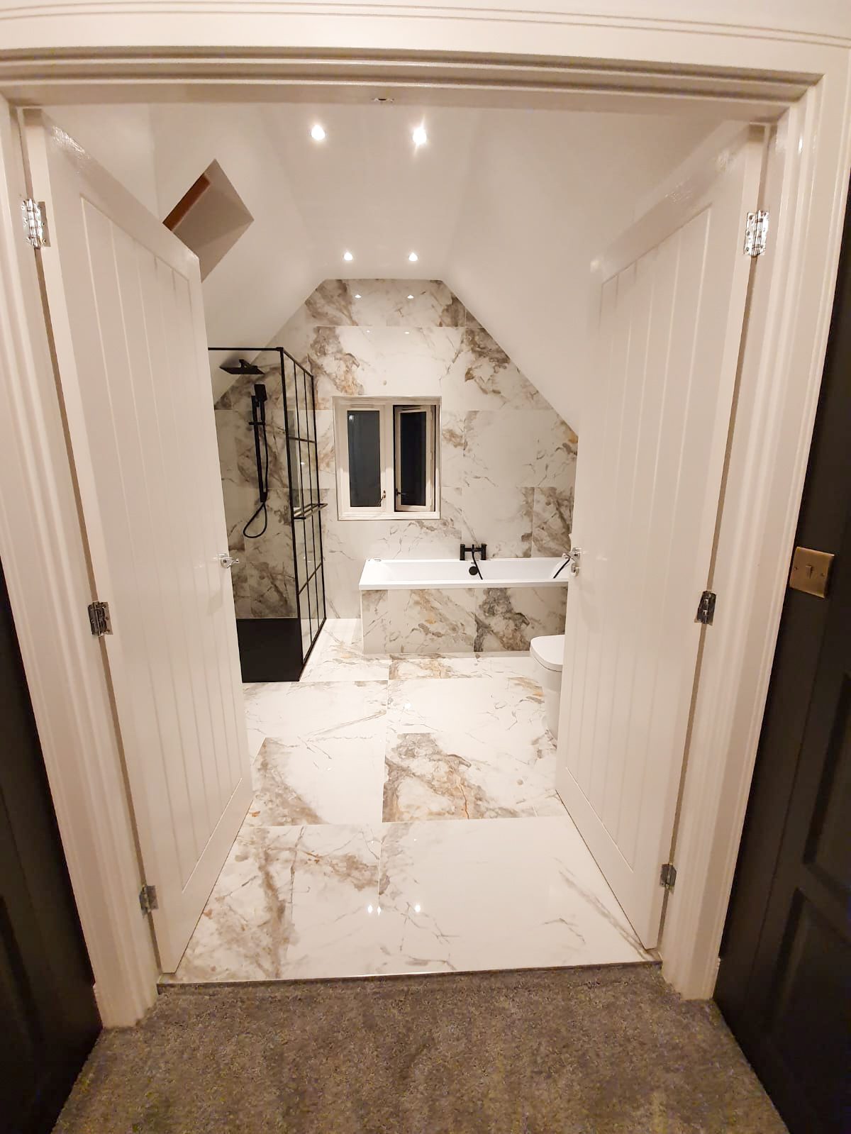 Marble bathroom with bathtub and glass shower