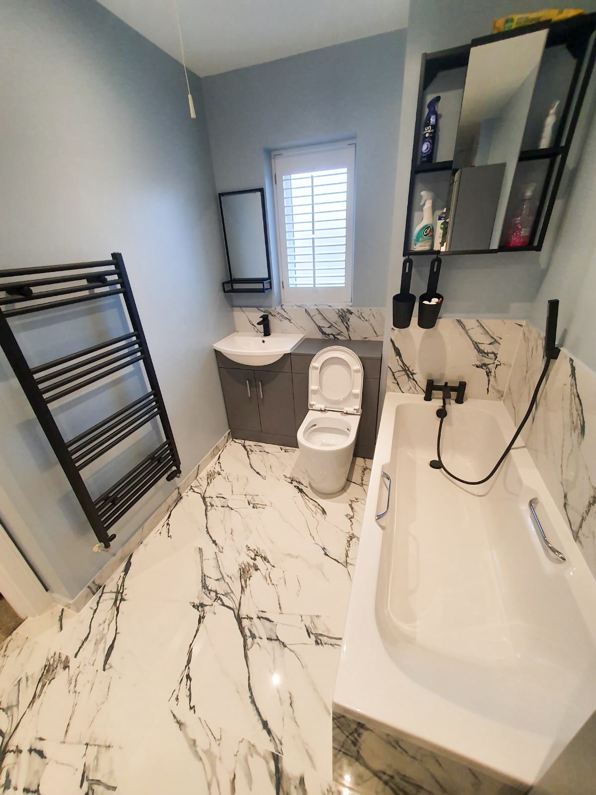 Modern bathroom with marble floor, tub, toilet