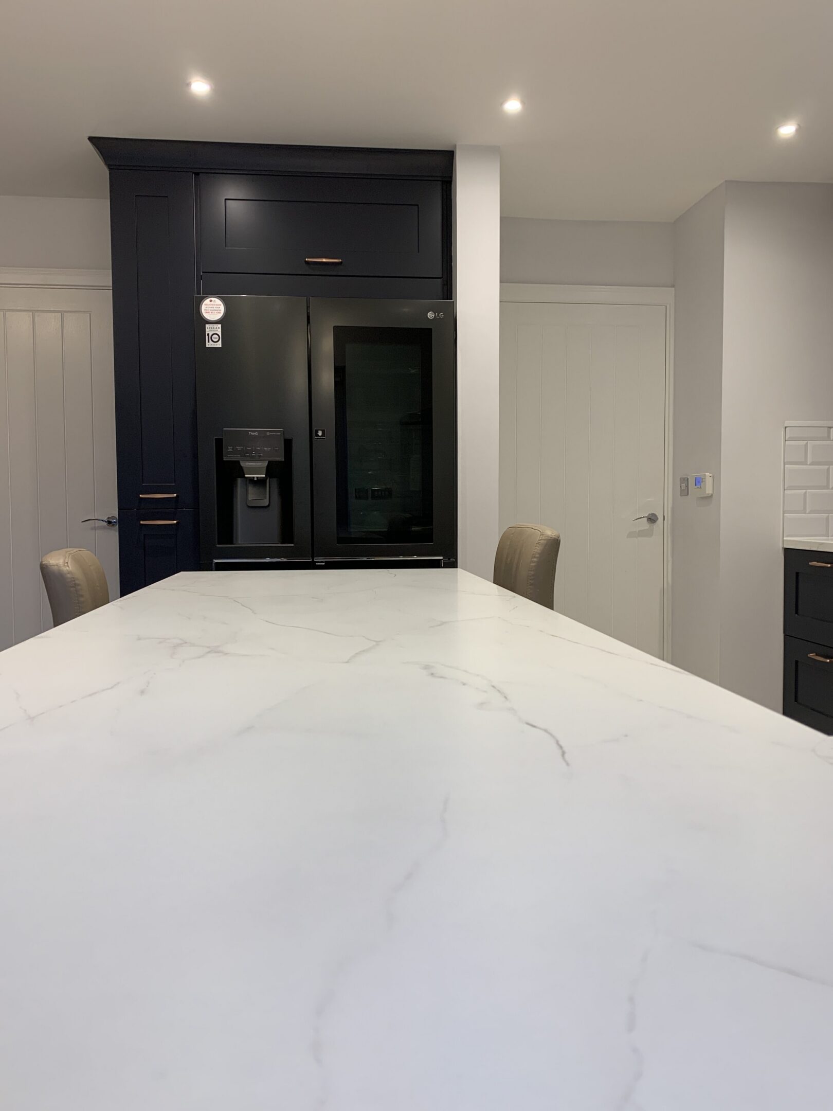 White marble kitchen island with dark cabinets