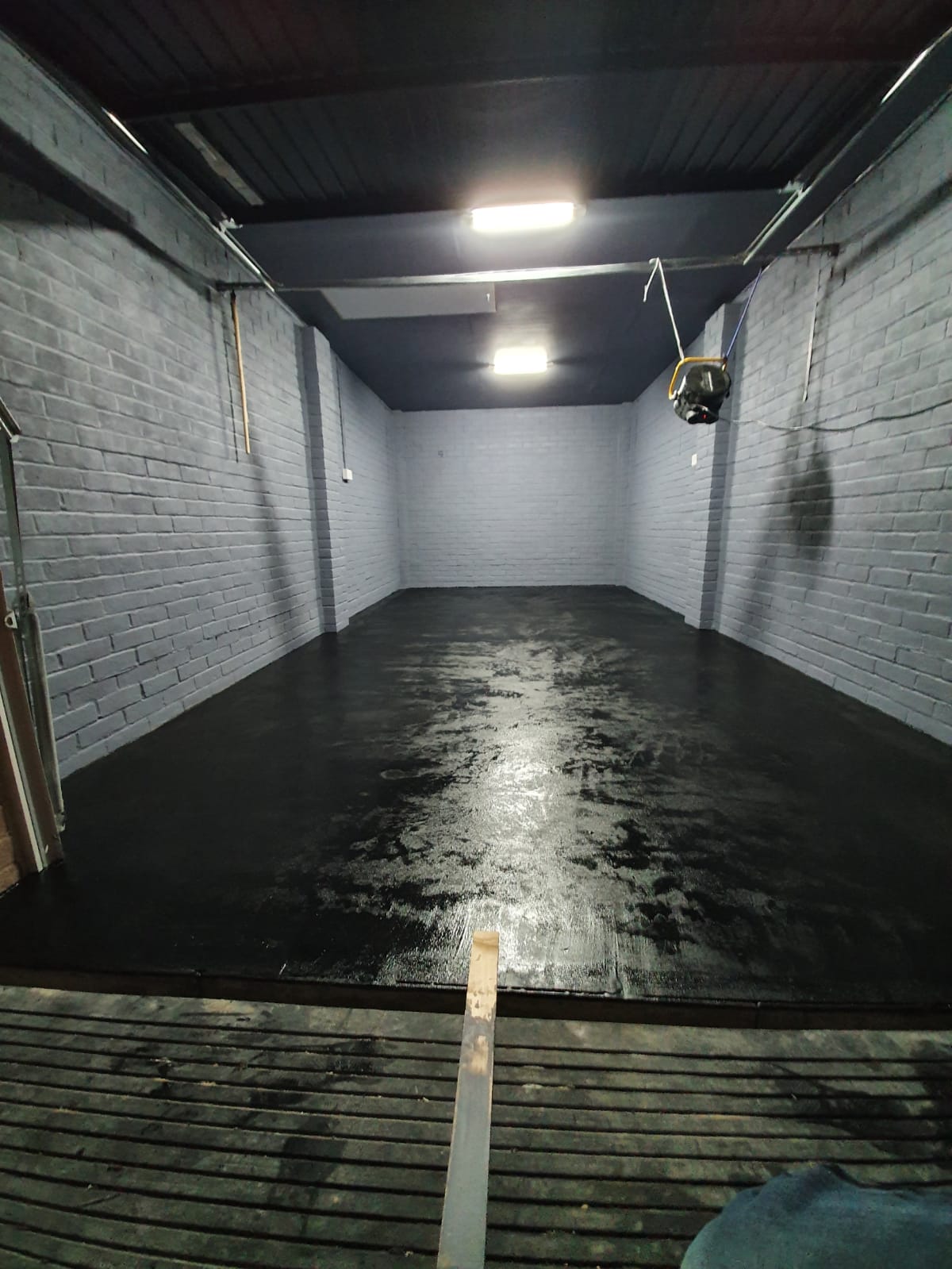 Empty garage with freshly painted glossy black floor