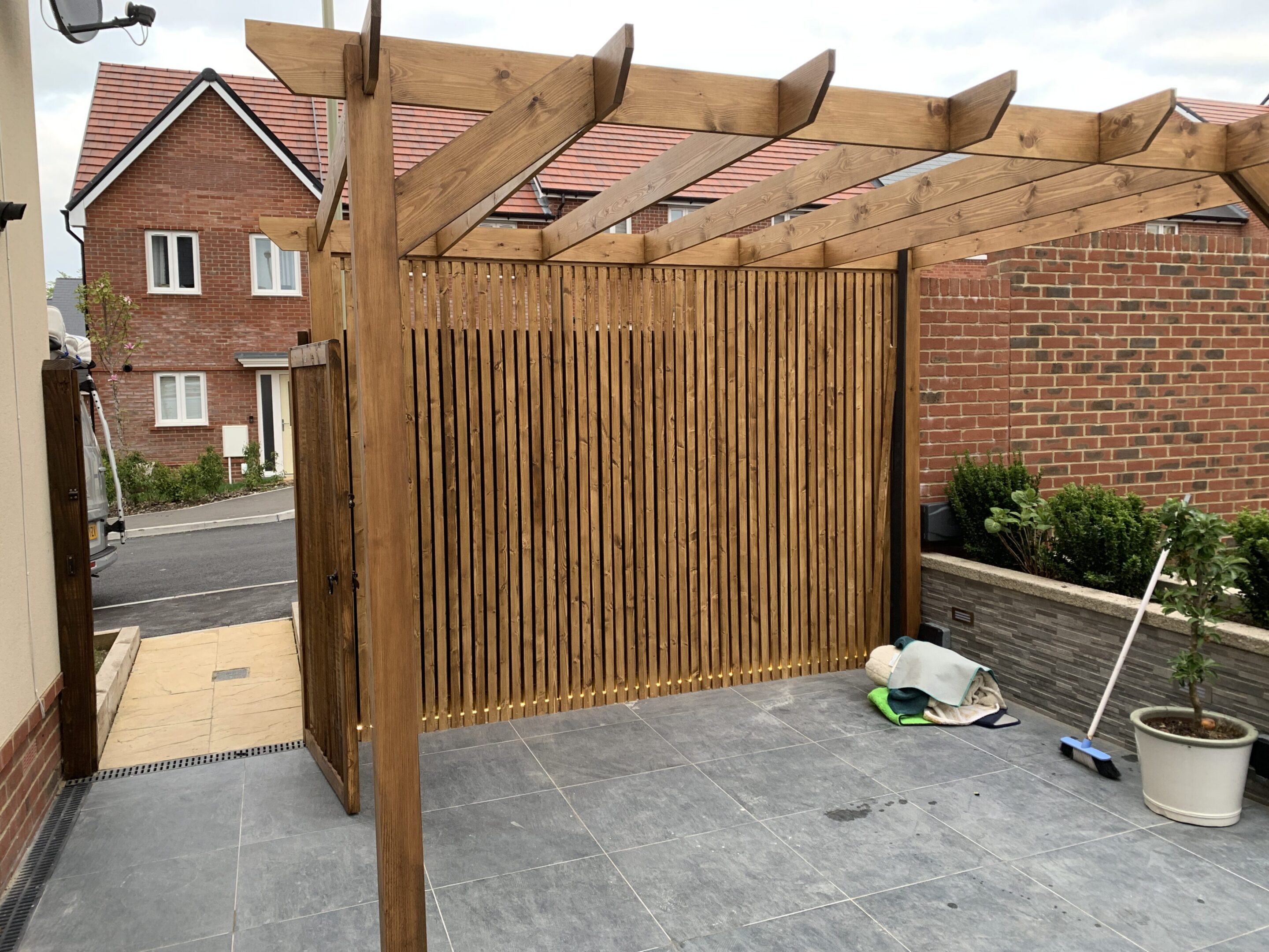 Wooden pergola with slatted privacy screen