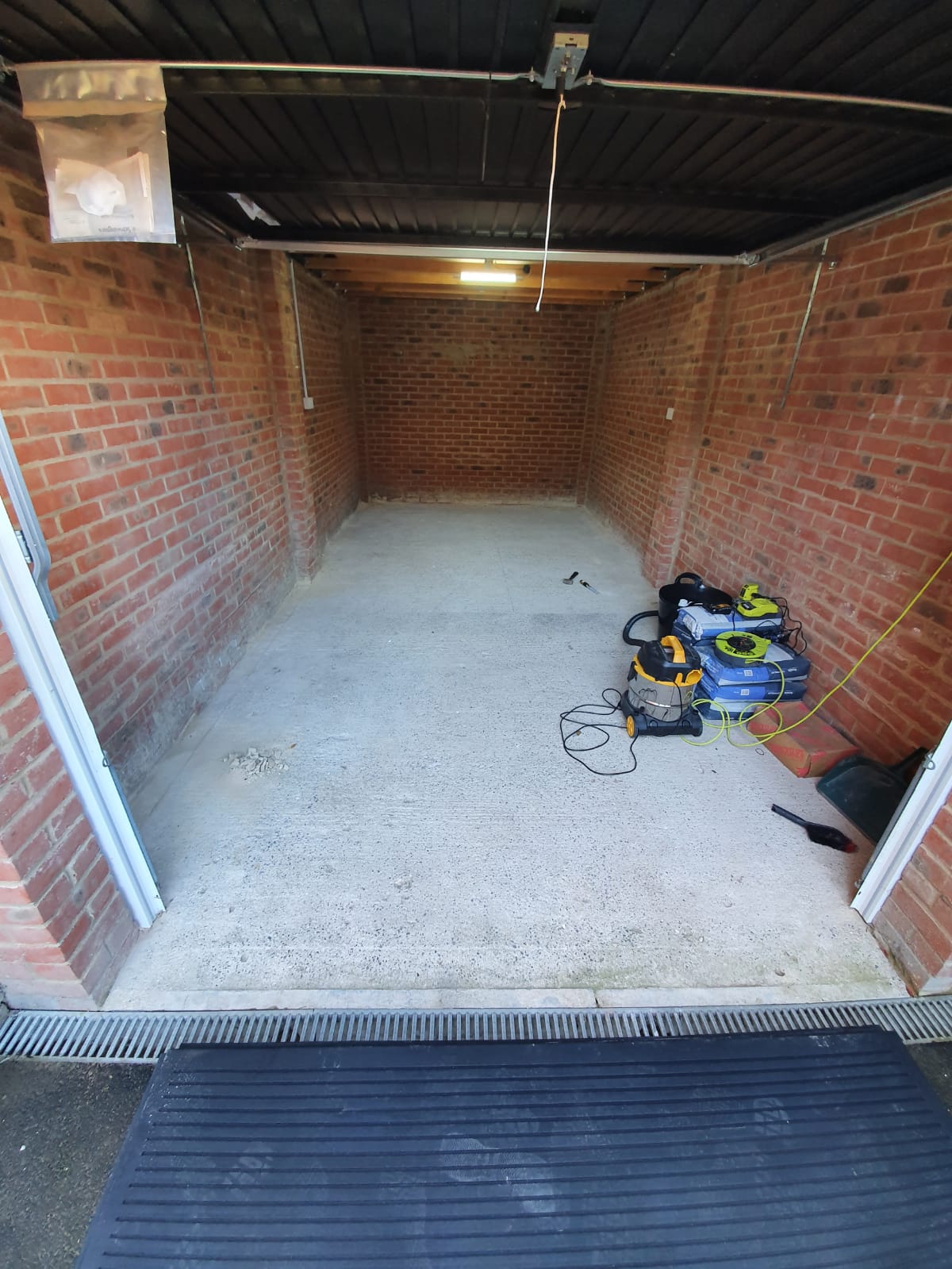 Empty single-car brick garage with tools