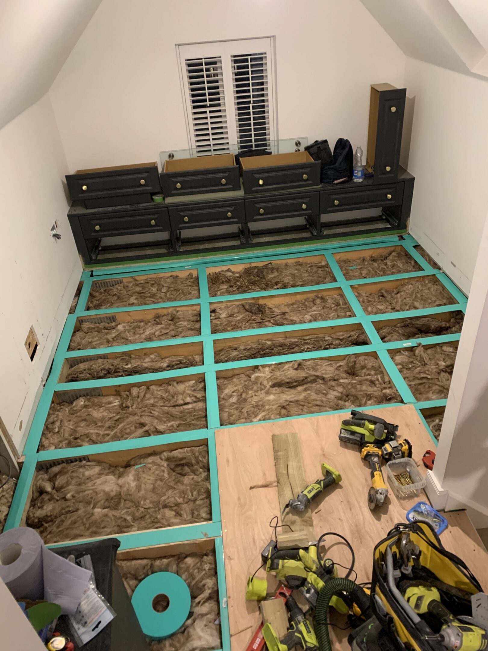 Room under renovation: exposed insulation and tools