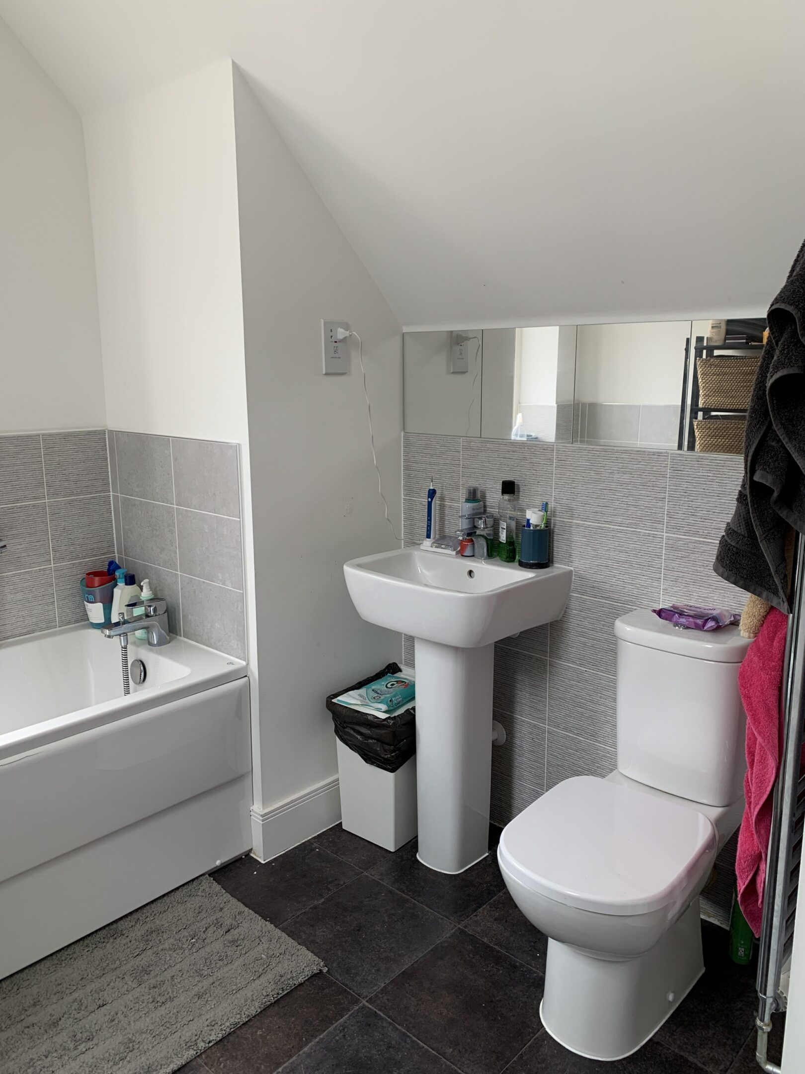 Small modern bathroom with bathtub, sink, toilet
