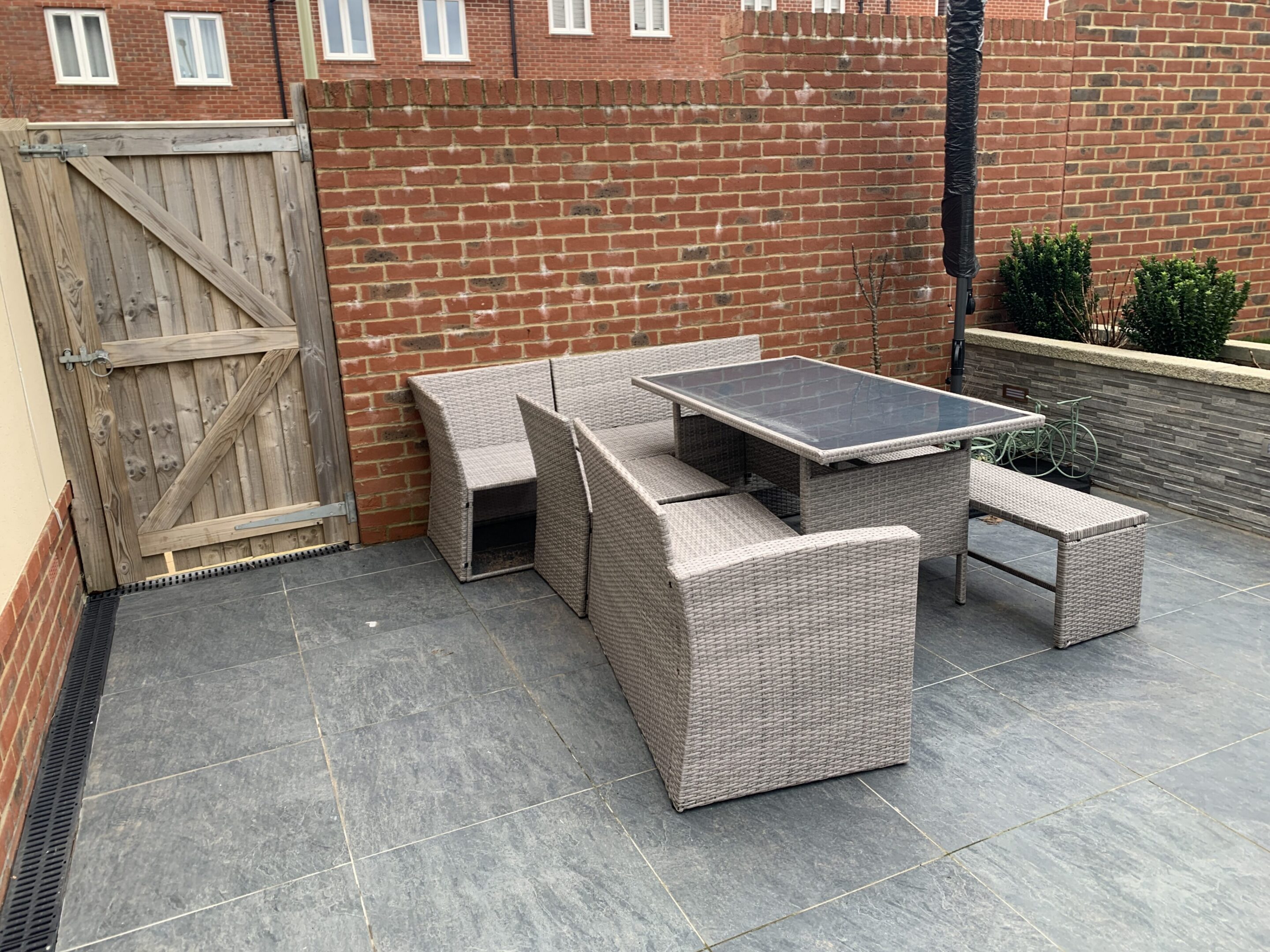 Grey rattan outdoor dining set on tiled patio