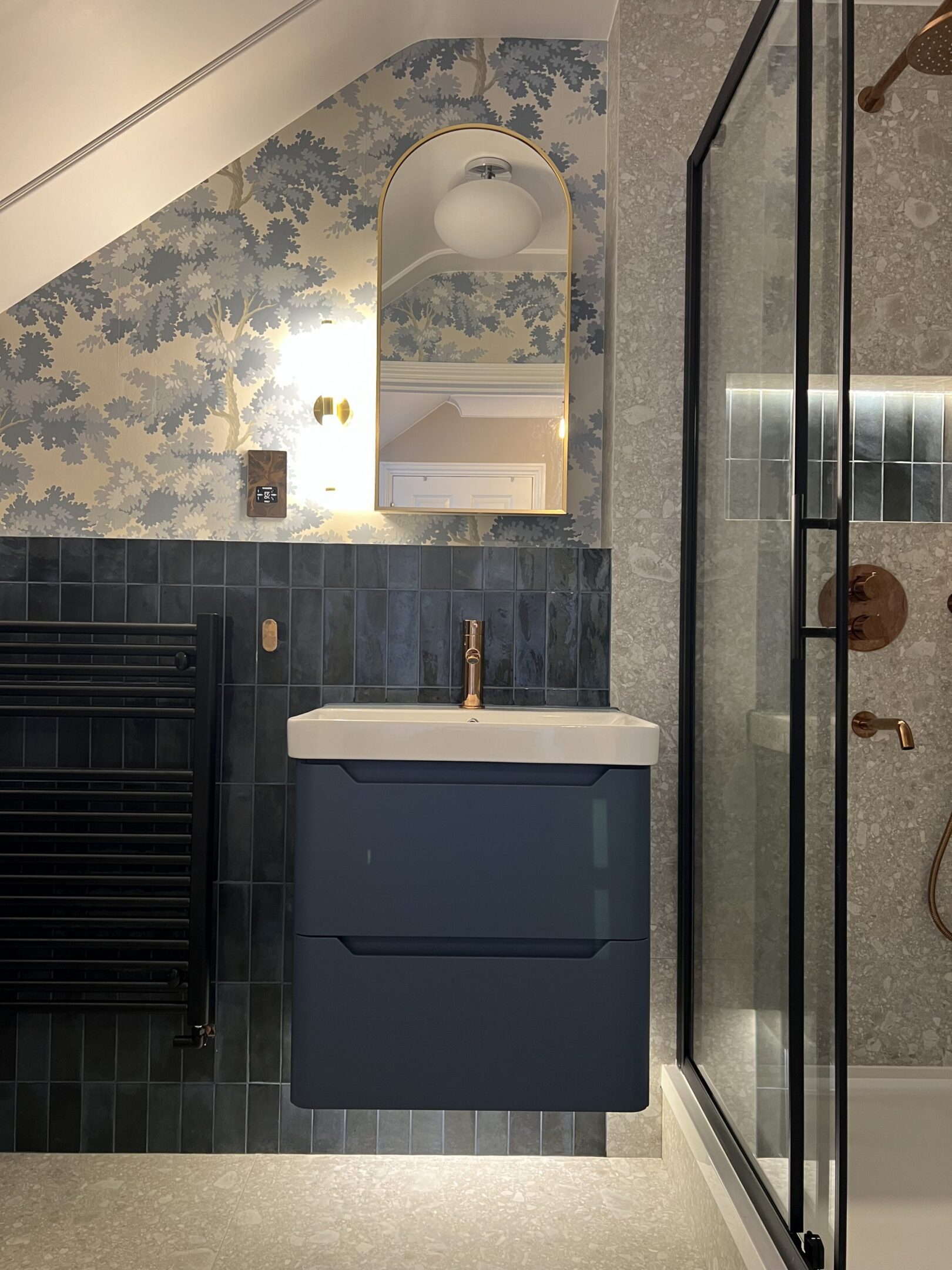 Navy floating vanity with mirror and brass fixtures
