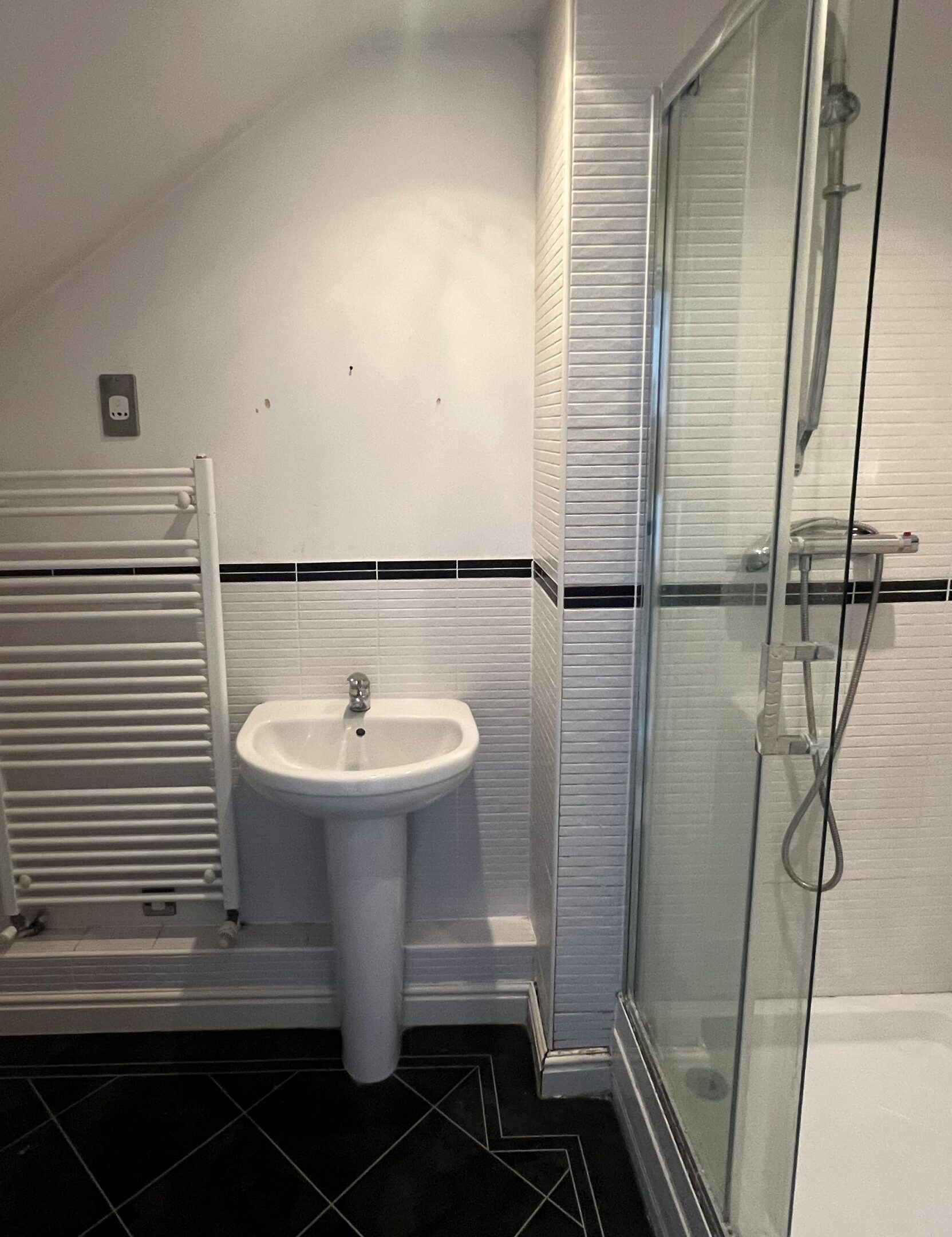 White tiled bathroom with pedestal sink and shower