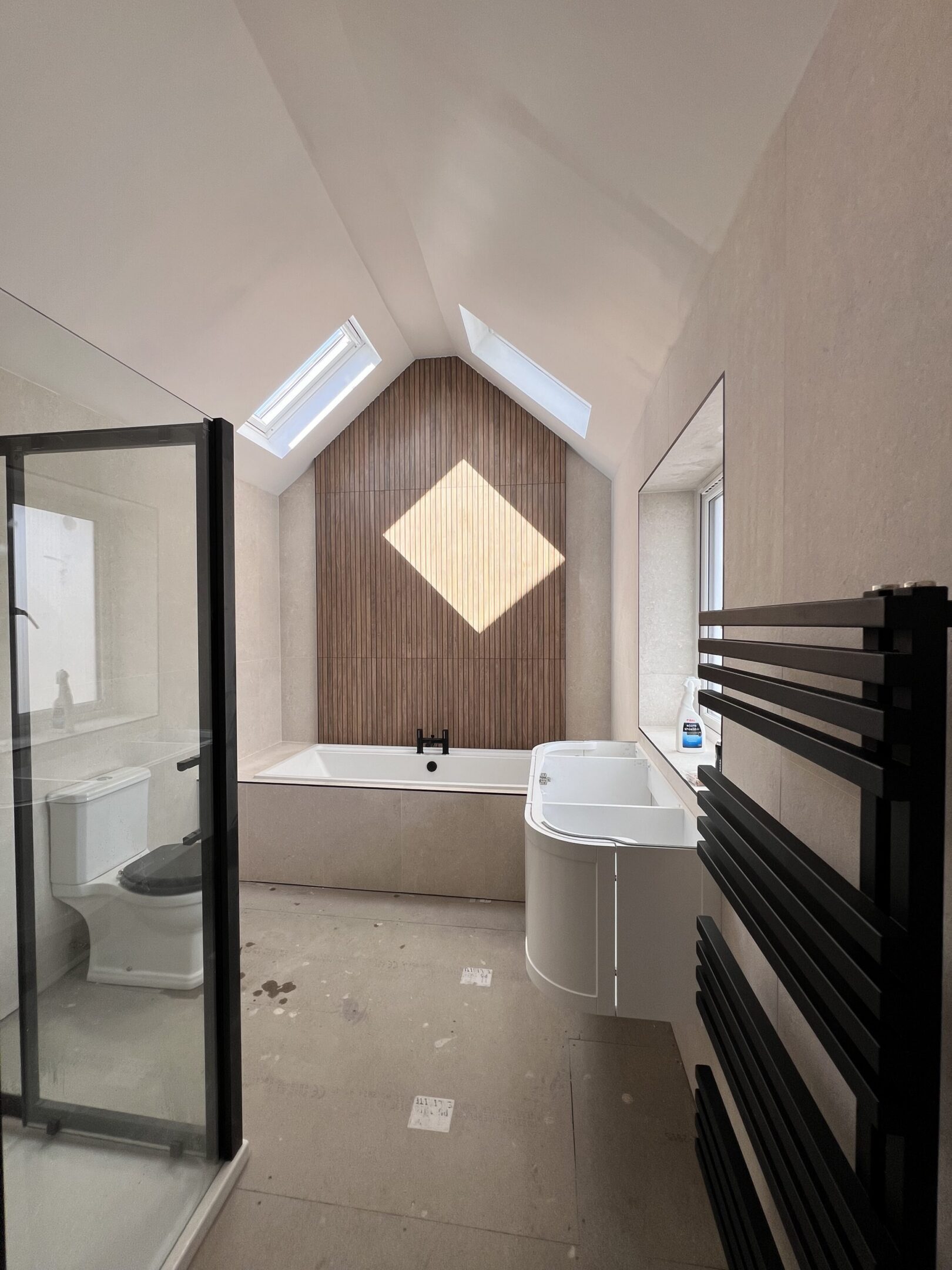 Modern skylit attic bathroom with bathtub