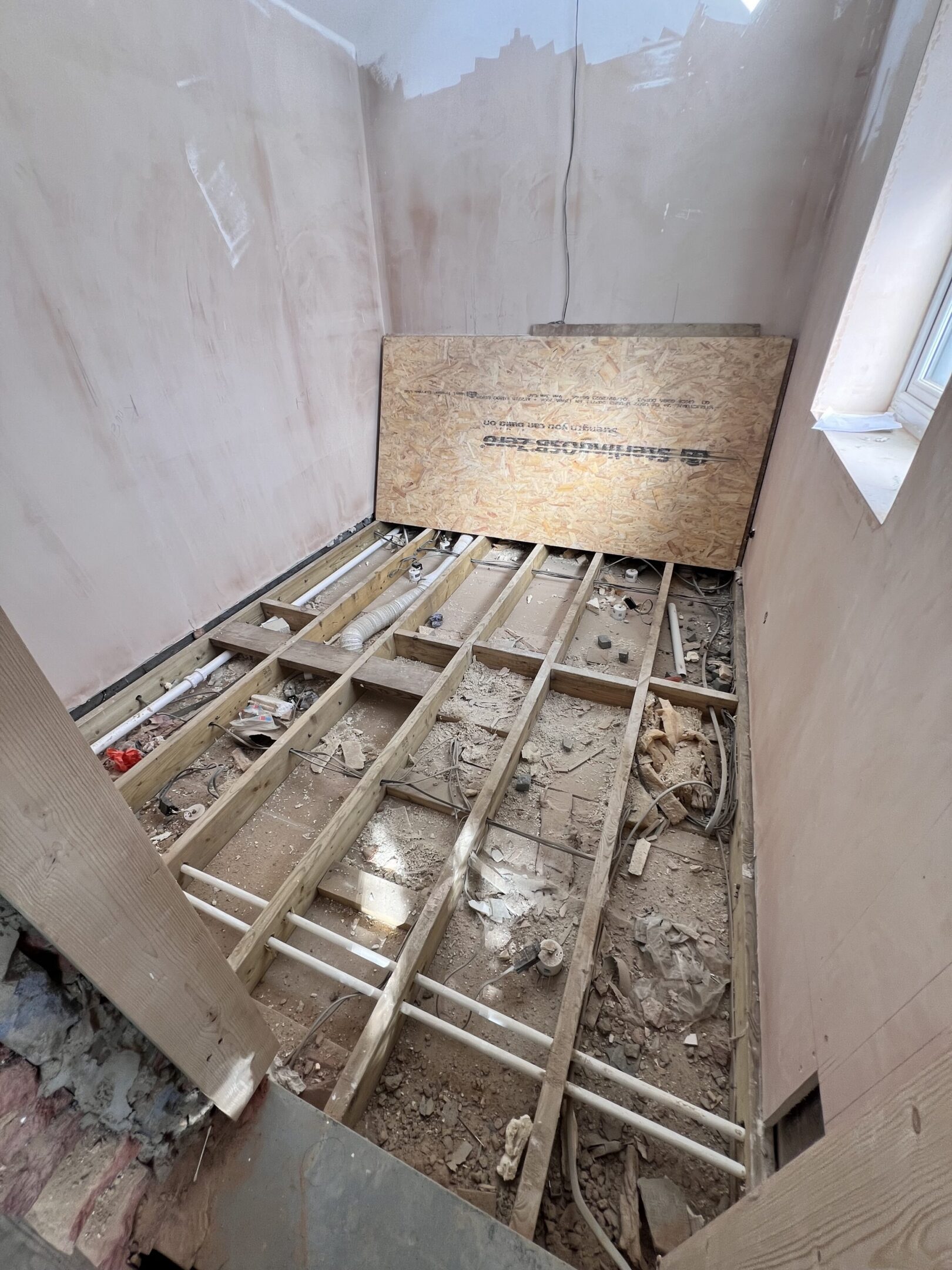 Small room under renovation with exposed floor joists