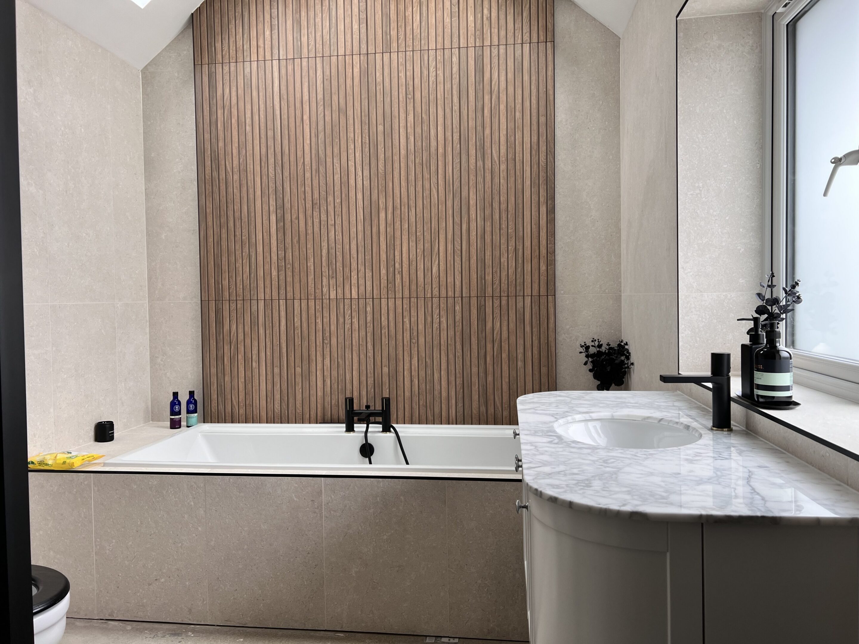 Modern bathroom with bathtub and wooden accent wall