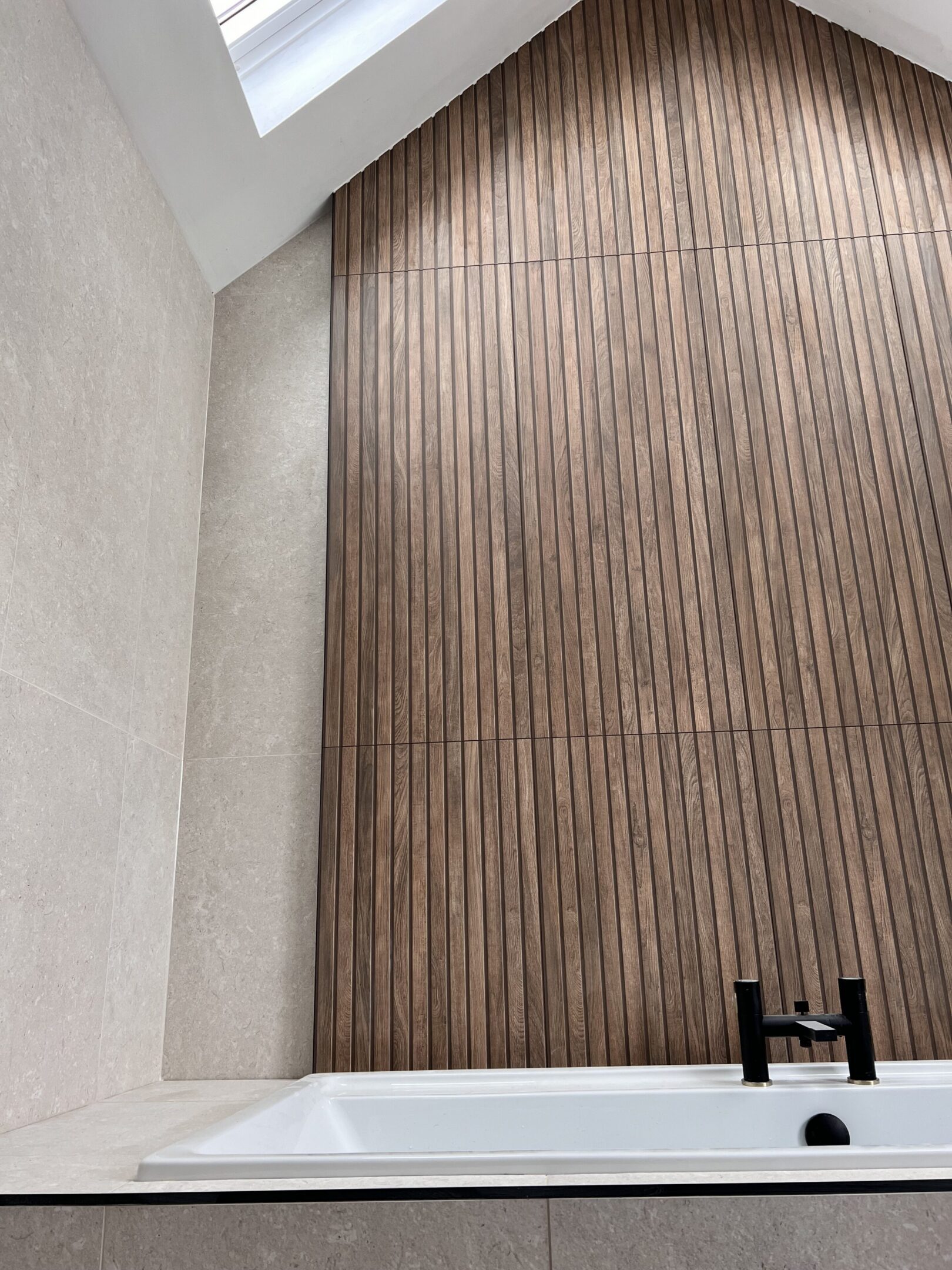 Modern bathroom with bathtub and vertical wood paneling