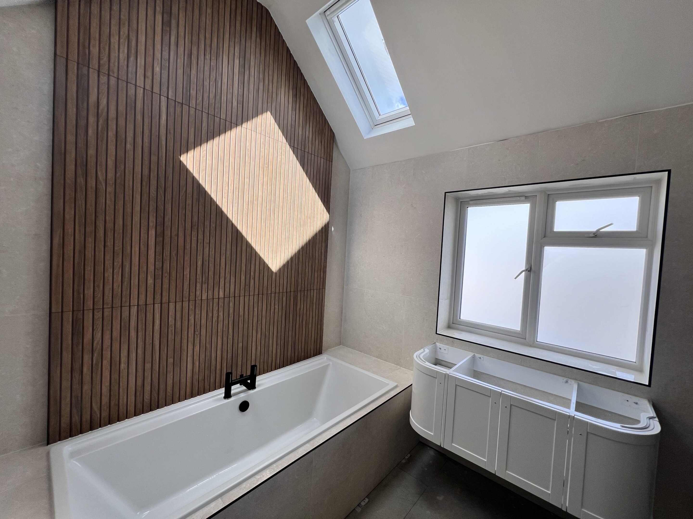 Modern bathroom with bathtub, wood accent wall